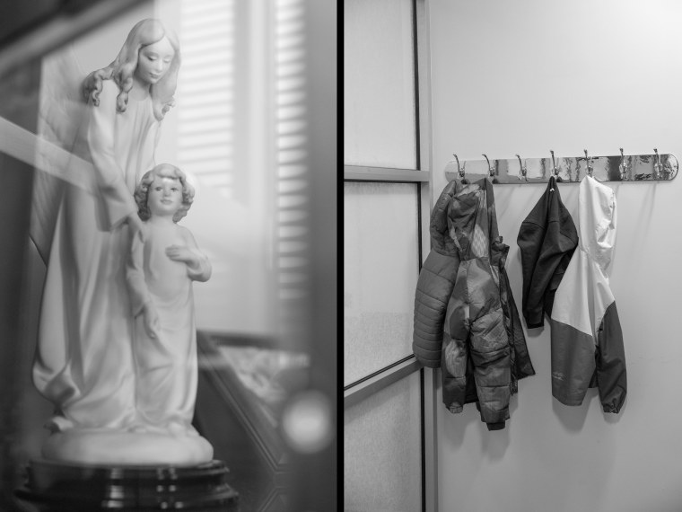 Side by side of a statue and children's coats on a rack