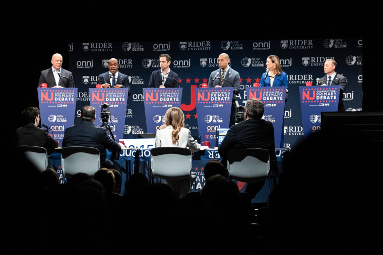 Standing onstage behind podiums, from left, Steve Sweeney, Ras Baraka, Steven Fulop, Sean Spiller, Mikie Sherrill and Josh Gottheimer