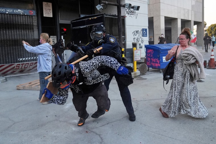 A protester attempts to evade a Department of Homeland Security officer 