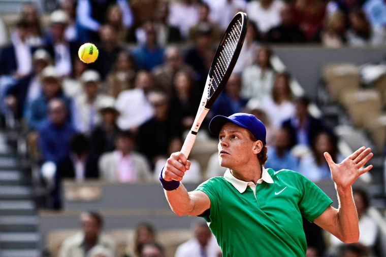 Jannik Sinner plays a backhand return on the tennis court