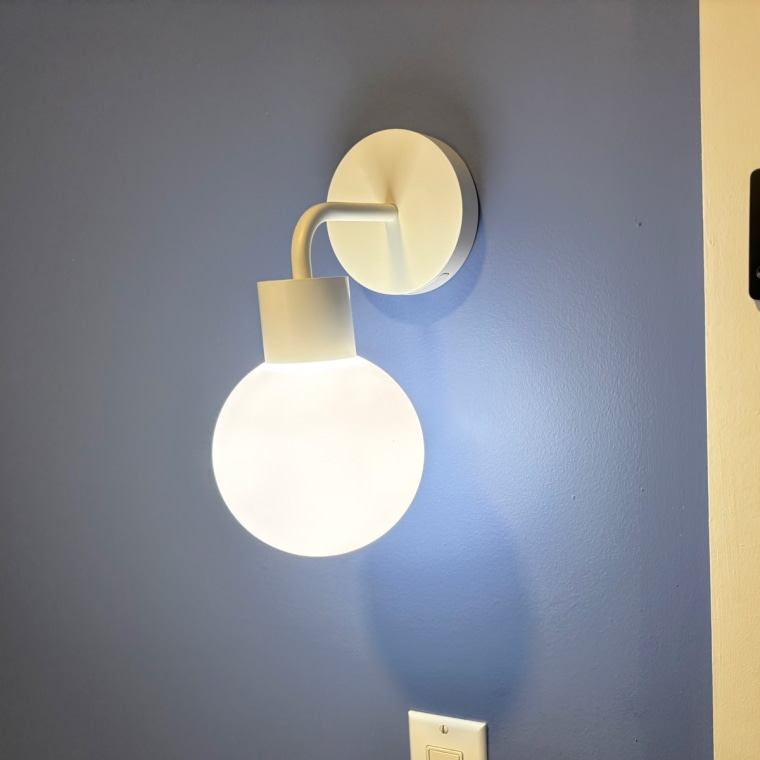 Poplight lit with warm light temperature in a dark bedroom with blue walls.