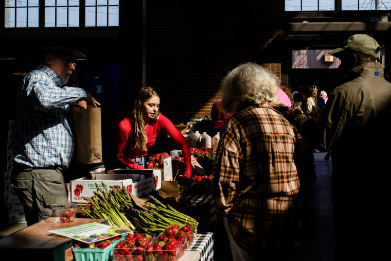 Vendors assist shoppers at a market.