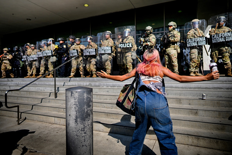 A protester in front of a line of California National Guard
