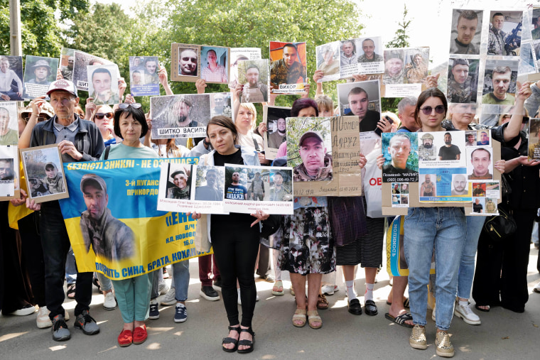Families holding signs and waiting for the instrumentality of Ukrainian prisoners of war