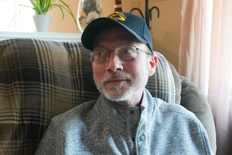 Eric Tennant seated on a couch