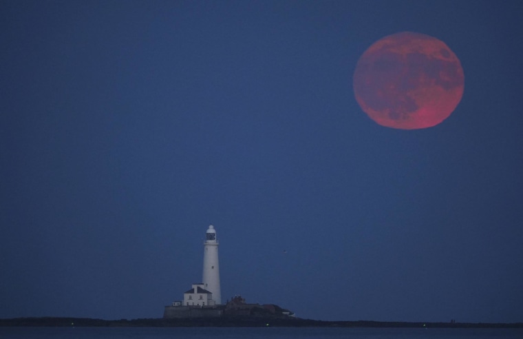The full moon rises over St. Mary's Lighthouse in Whitley Bay, England, Tuesday, June 10, 2025. 