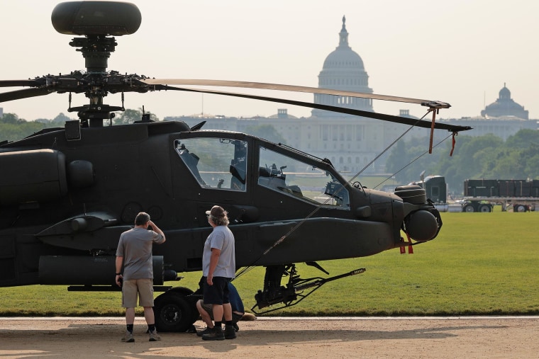 People intermission to look astatine a U.S. Army AH-64 Apache onslaught chopper parked connected show connected the National Mall connected June 11, 2025.