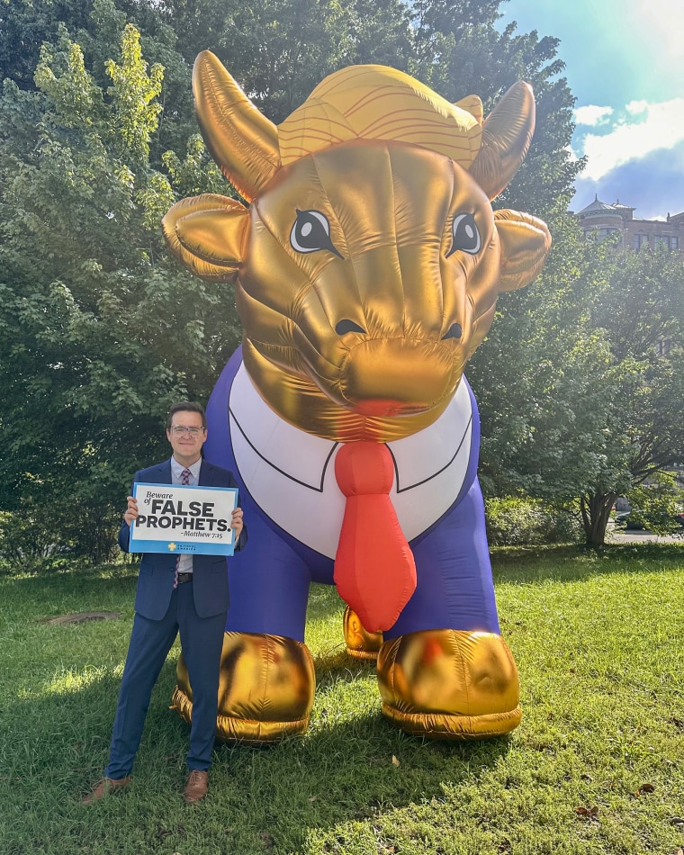 The writer poses with the Trump Golden Calf balloon created by Faithful America, an online community of progressive Christians.