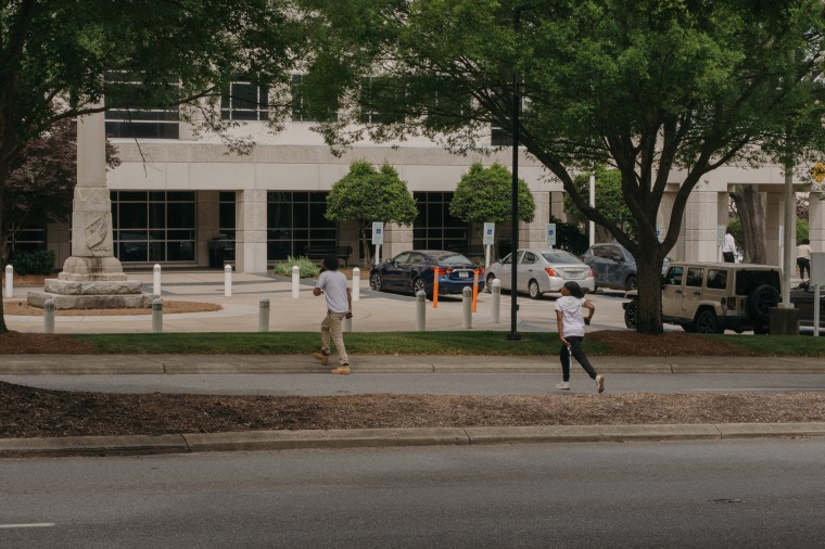 People running to cross Martin Luther King Jr Blvd in front of the Gaston County courthouse