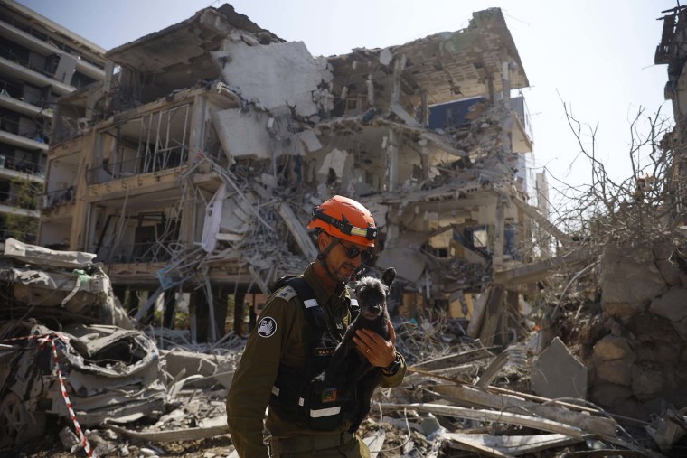 An emergency worker carries a rescued dog named Tes from a building damaged in an overnight strike on June 14, 2025 in Ramat Gan, Israel.