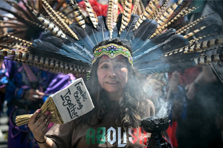 Image: A woman wearing a headdress and fanning incense.
