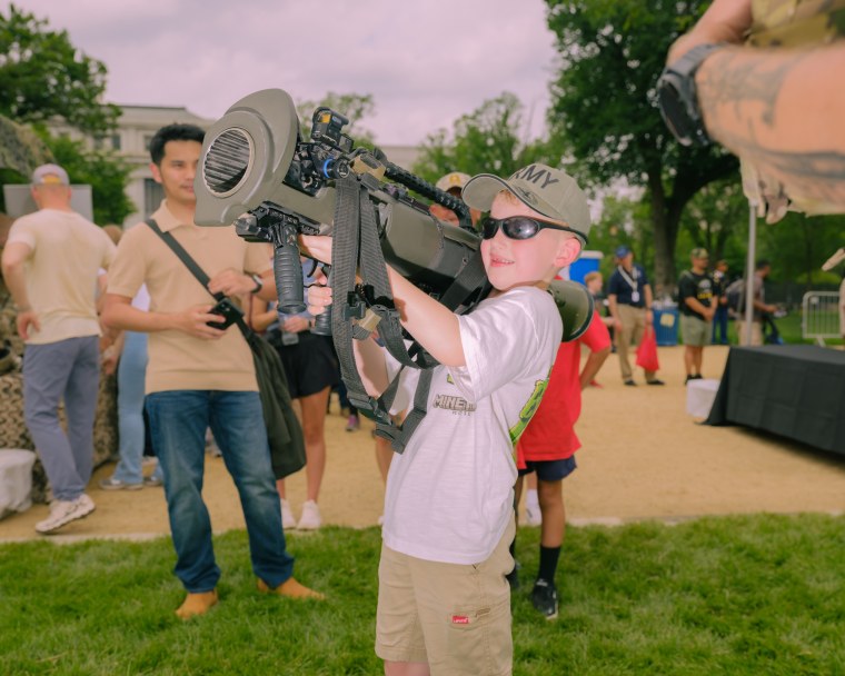 A young child holding a large weapon.