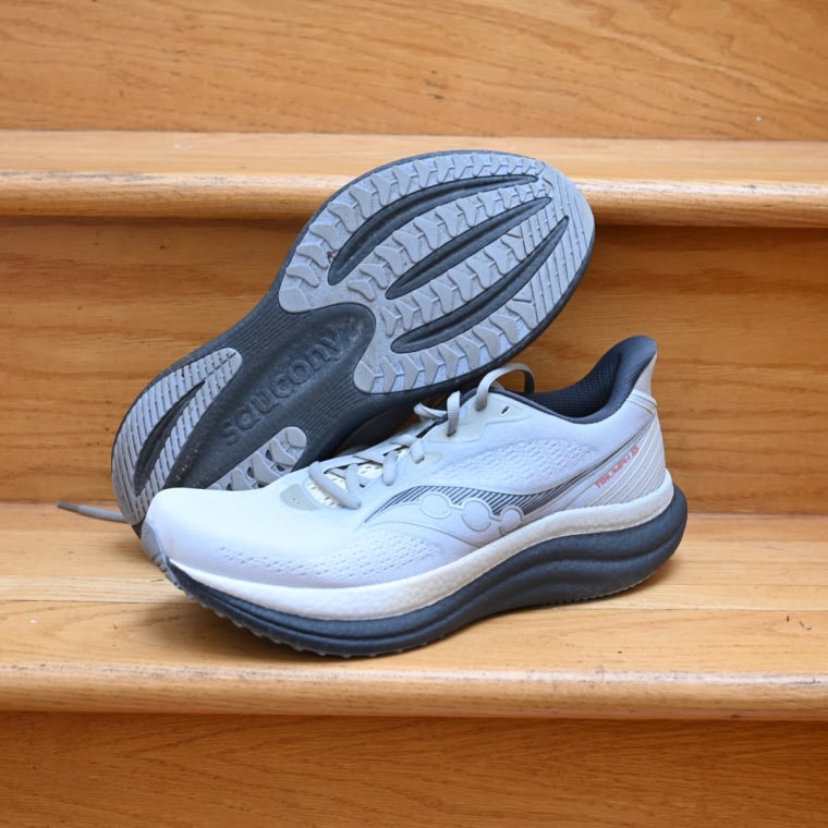 A close up of the Saucony Triumph 23 shoes. One shoe is propped to show the bottom tread.