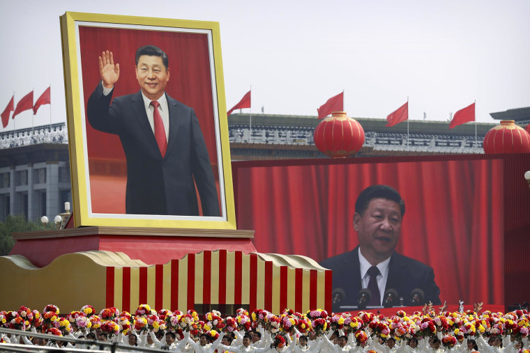 Participants cheer in Beijing beneath a large portrait of President Xi Jinping during a parade in 2019 to commemorate the 70th anniversary of the founding of Communist China.