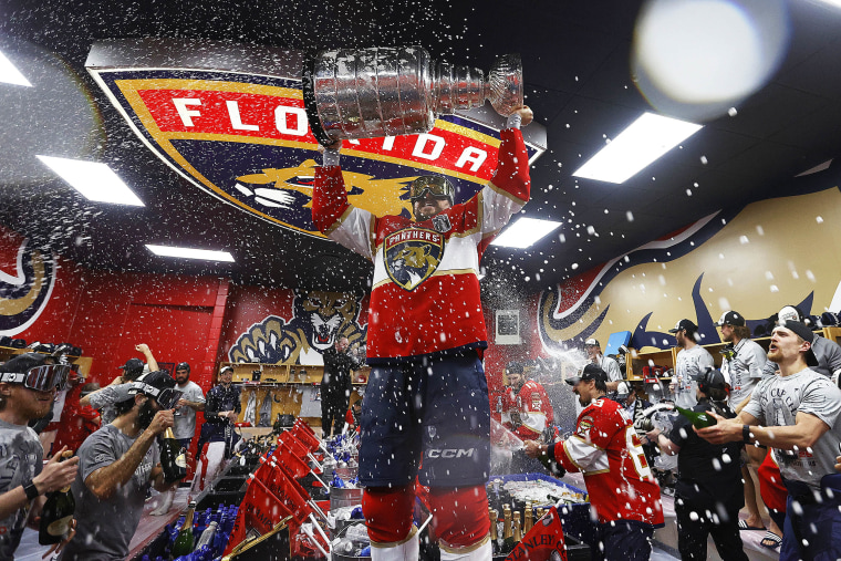Sam Reinhart #13 of the Florida Panthers lifts the trophy in the locker room