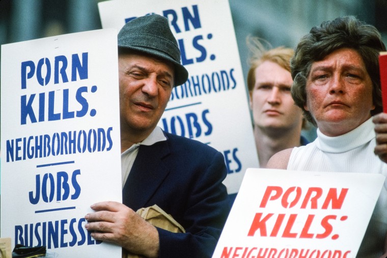 People carry signs that read 'Porn Kills: Neighborhoods, Jobs, Businesses.'