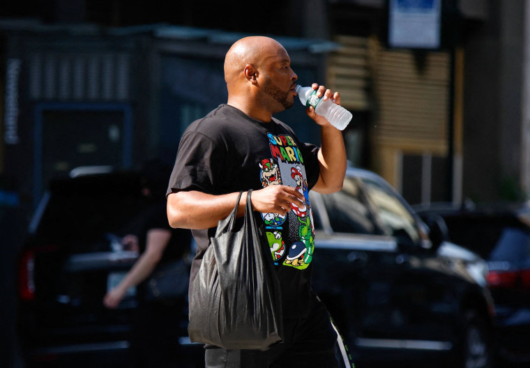 Em 22 de junho de 2025, um homem bebeu água quando uma estrada atravessou durante a onda de calor na cidade de Nova York.