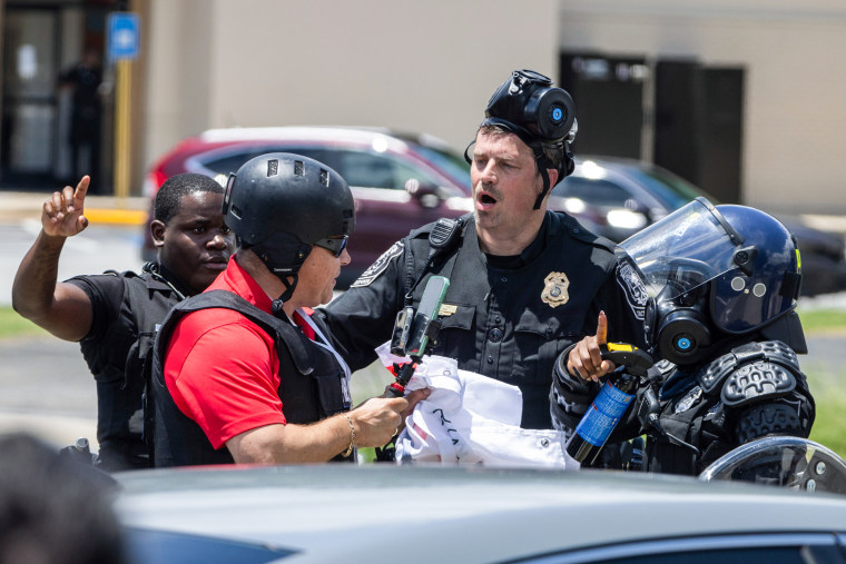 Backlash after ICE detains journalist covering 'No Kings' immigration protests Two police officers speak to Mario Guevara outside