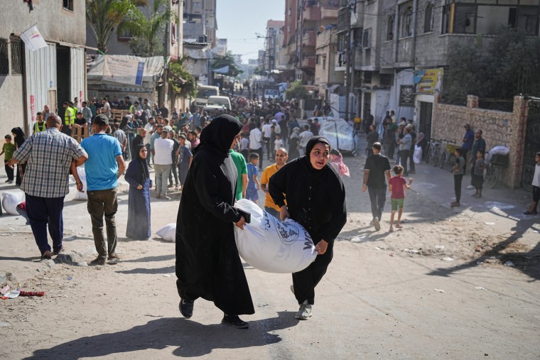 Palestinians carry bags of flour outside