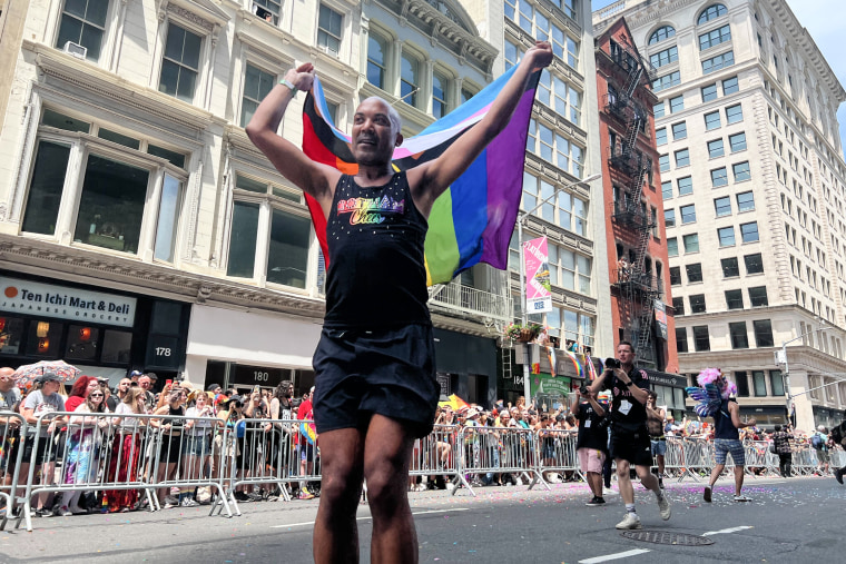 A person holds a Pride flag on the street