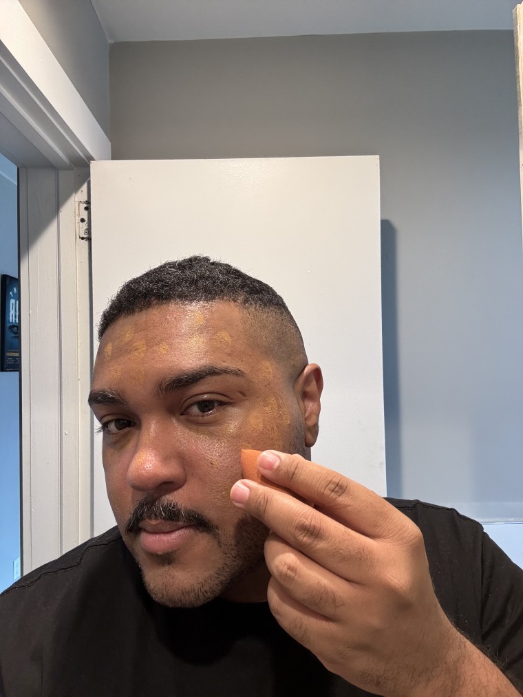Man applying foundation on face using a Beautyblender makeup sponge