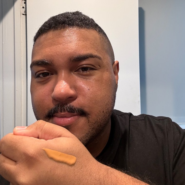 Man with swatch of foundation on the back of hand