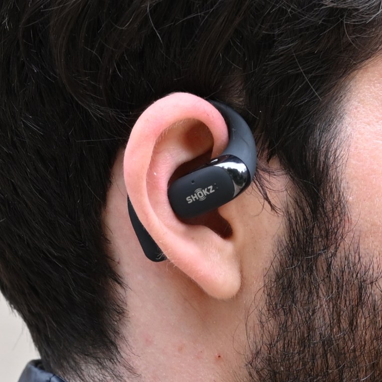 A close up of a Shokz Openfit 2 earbud on the ear of the writer.