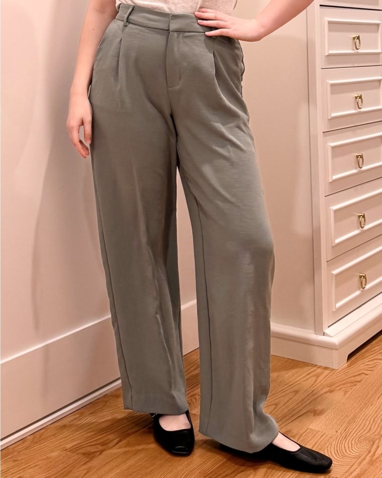 A photo of NBC Select page Riley Atkinson wearing the green signature crepe essential trouser.