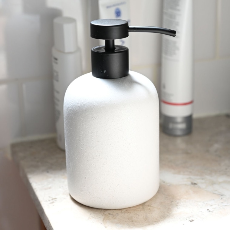 A close up of the West Elm Kaloh Soap Pump on a stone countertop in a bathroom