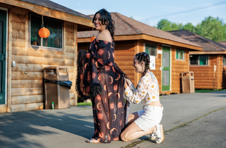Brittany Malo, 36, looks on while Kim Cain, 34, helps her with her outfit at Camp Breastie.