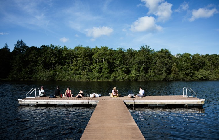 People spend time at the lake at Camp Breastie.