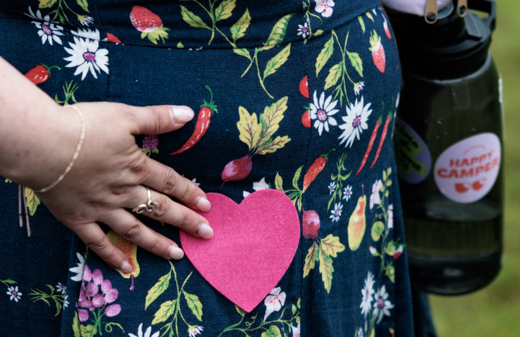 Liz Rainey, 40, touches a heart patch she was given at Camp Breastie.