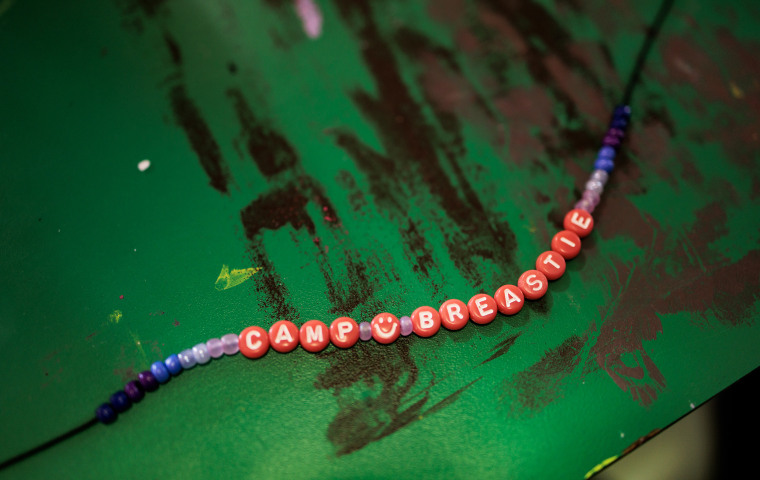 A bracelet made during arts and crafts that reads "Camp Breastie."