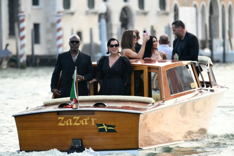 From left : Corey Gamble, US television personality Kris Jenner, Khloe Kardashian and US reality TV personality Kim Kardashian stand on a taxi boat as they leave the Gritti Palace Hotel ahead of the wedding of Amazon's founder Jeff Bezos with Lauren Sanchez in Venice on June 26, 2026. Celebrities in superyachts sail into Venice this week for the three-day wedding party of Amazon tycoon Jeff Bezos and Lauren Sanchez, despite irate locals who say the UNESCO city is no billionaire's playground. The tech magnate and journalist have reportedly invited about 200 guests to their multi-million dollar nuptials in the Italian city, which are expected to kick off on June 26 and end Saturday with a ceremony at a secret location. 