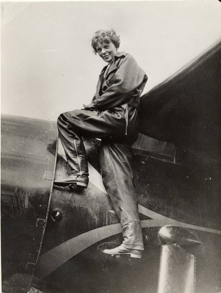 Amelia Earhart on the side of her Lockheed Vega 5B from her solo Atlantic flight.  