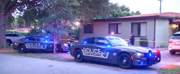 Police cars with lights on in front of a house outside