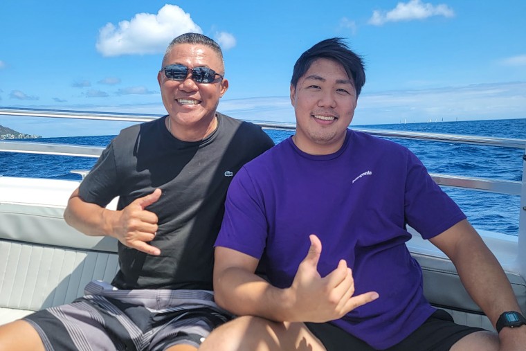 Two men sit next to each other on a boat