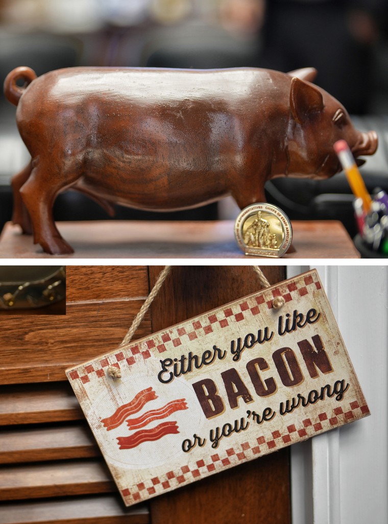 A diptych of a wooden pig and a sign that reads " Either you like bacon or you are wrong" In the Don Bacon office on Capitol Hill.