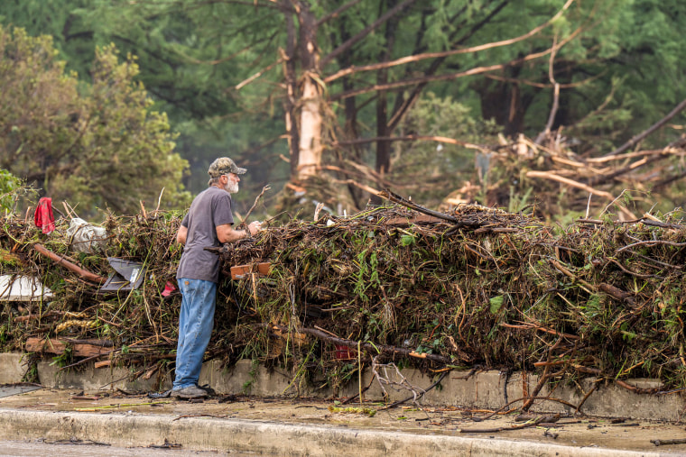 A resident surveys flood damage and debris along the Guadalupe River.