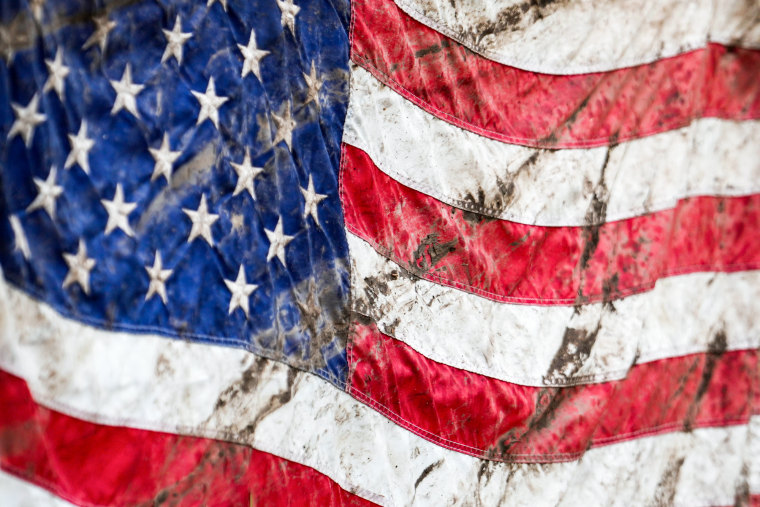 An America flag, covered in dirt