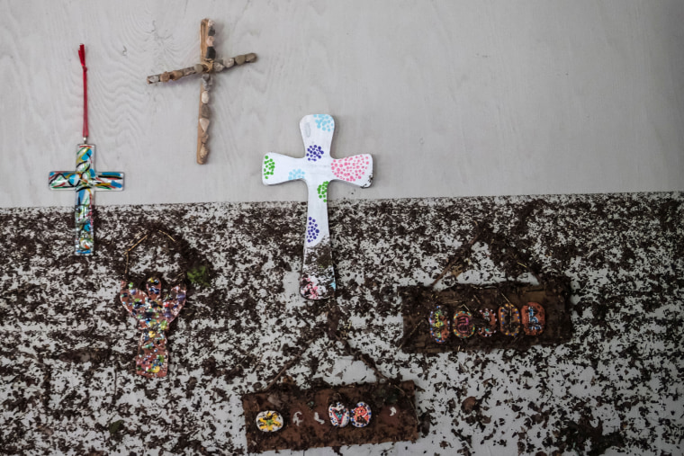 Crosses hang from a wall with flood marks
