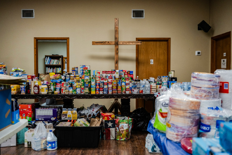 Food and other items inside of a room in front of a large cross