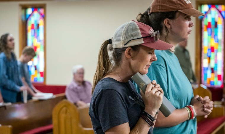 Ginger Turner and Hailey Turner pray inside of a church