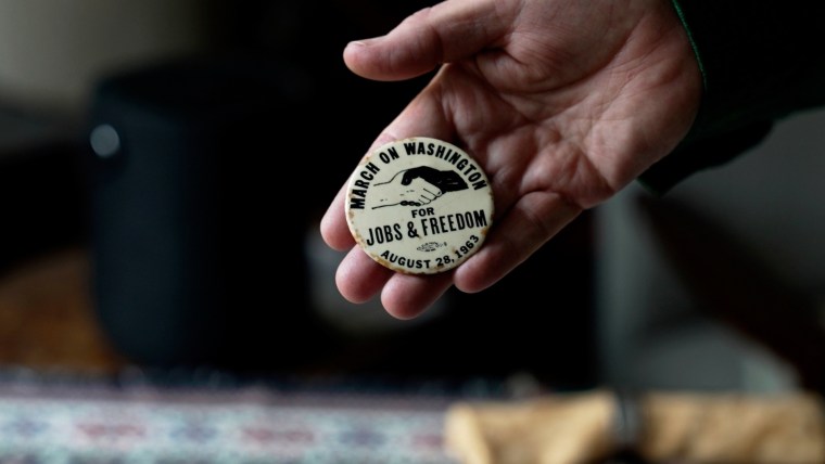 A button from the March on Washington for Jobs an Freedom is held by Walter Naegle