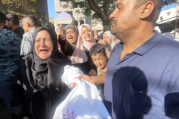Nasar Sebetaa, right, carries the body of his niece, Yaqeen, a 5-month-old killed with her parents in an Israeli strike on Gaza.