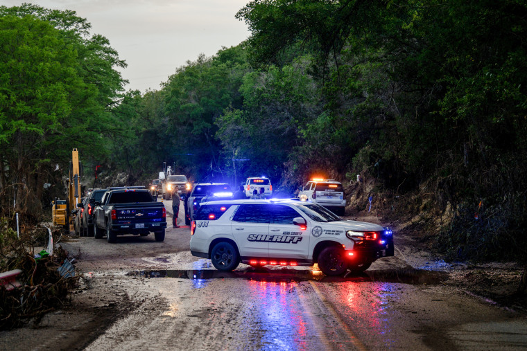Police cars and officials on a muddy road
