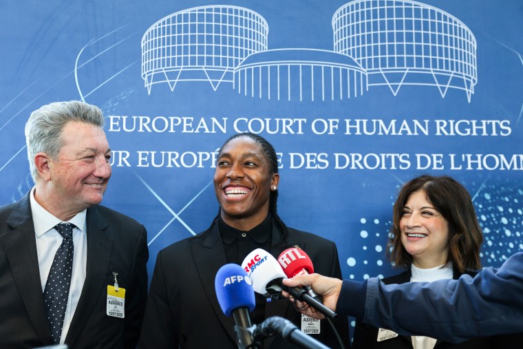 Caster Semenya smiles, center, between lawyers Gregory Nott, left, and Shona Jolly KC