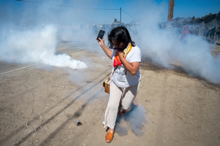 A protester runs from tear gas