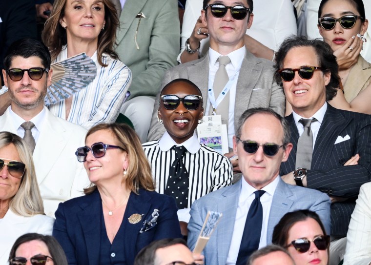 Cynthia Erivo, center, sits in the audience of a tennis match outside