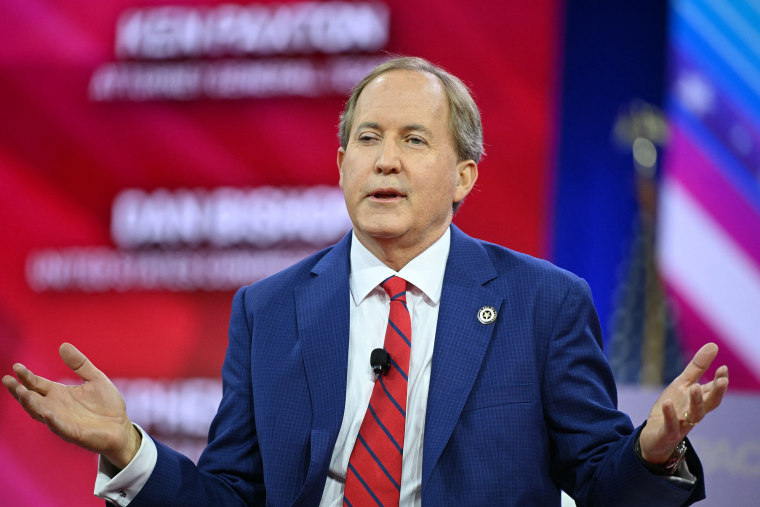 Ken Paxton gestures while speaking.